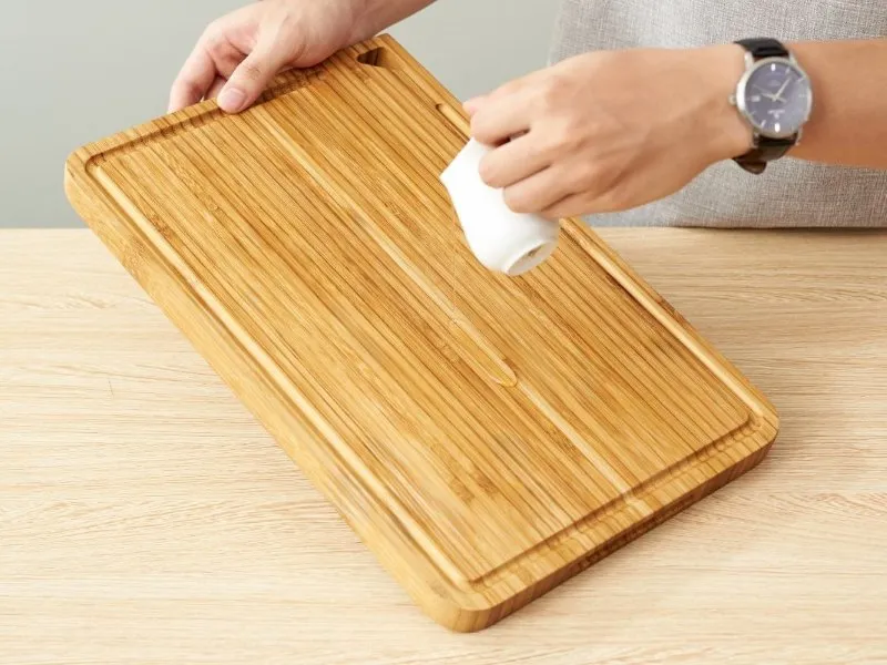 Applying oil to wooden cutting board for maintenance